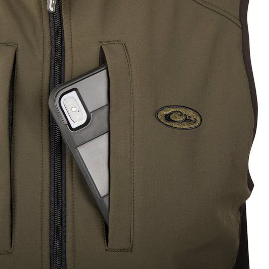 A close-up of the EST Windproof Tech Vest with a phone in the pocket, showcasing its functionality and style.
