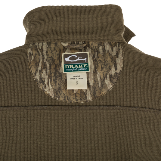 MST Windproof Softshell Vest - A close-up of the jacket with a label and logo. Expert-level functionality with secure storage pockets and customizable fit. Superior comfort and breathability with 4-Way Stretch and Grid-Fleece Collar Lining.