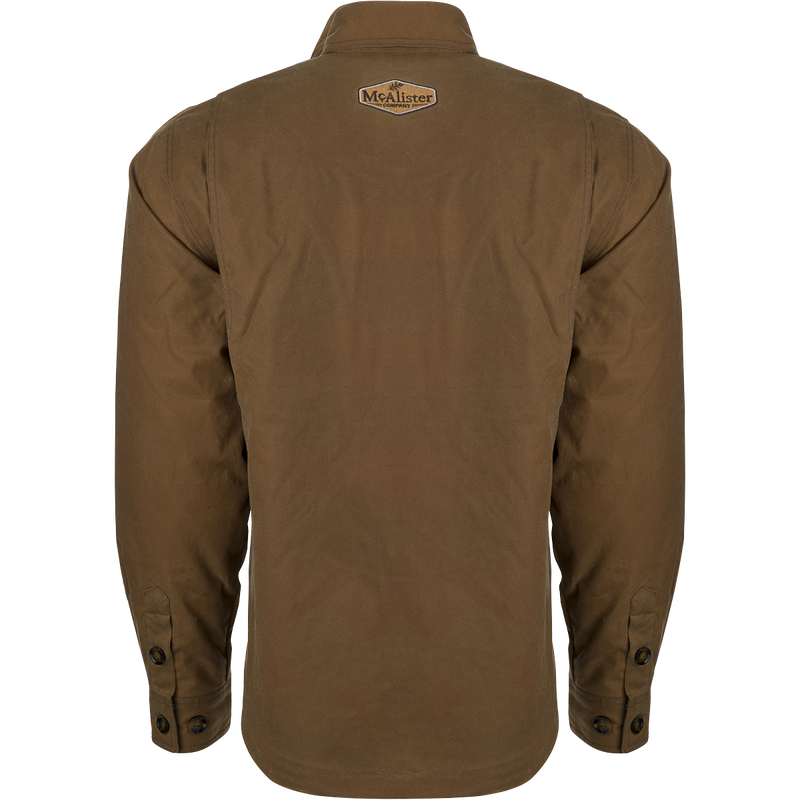 McAlister Waxed Cotton Jac-Shirt, a brown jacket with a white logo on it. Water and wind-resistant, with a heritage look and functional fit. Fleece-lined hand pockets.