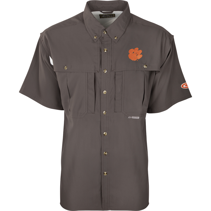 Clemson S/S Flyweight Wingshooter: A grey shirt with an orange logo and tiger paw patch. Made of ultra-lightweight polyester for quick-drying and breathability. Features include UPF 50+ sun protection, vented back design, Magnattach™ chest pocket, and vertical zipper pocket. Ideal for warm-weather outdoor activities.
