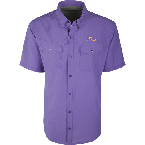LSU S/S Traveler's Shirt, a purple button-up with a yellow logo. Lightweight, breathable fabric with four-way stretch for comfort. Ideal for football games or weekend tailgates. Moisture-wicking with 2 chest pockets.