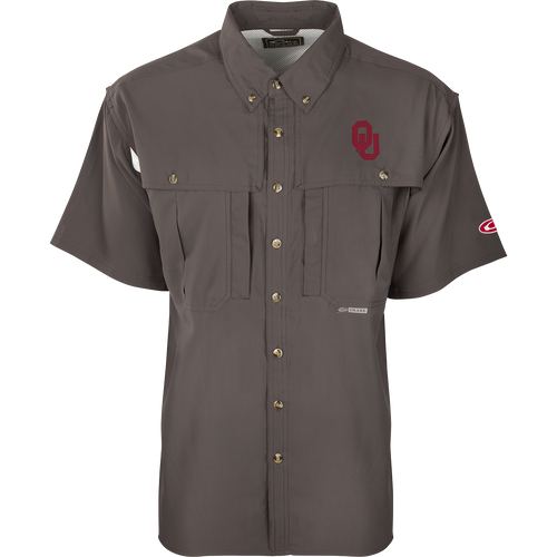 A close-up of the Oklahoma S/S Flyweight Wingshooter shirt, featuring a logo, vented back design, and multiple pockets. Lightweight, breathable, quick-drying, and moisture-wicking, this shirt is perfect for warm-weather outdoor activities. Made of 100% polyester with UPF 50+ sun protection.
