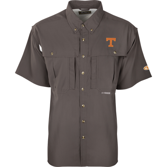 Tennessee S/S Flyweight Wingshooter: A grey shirt with a logo, designed for warm-weather outdoor activities. Made of ultra-lightweight polyester fabric for quick-drying and moisture-wicking. Features UPF 50+ sun protection, vented back, Magnattach™ chest pocket, and a vertical zipper pocket.