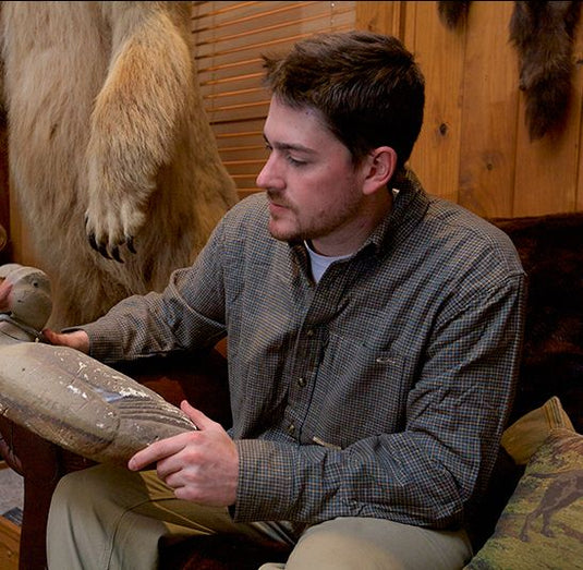 A man sitting in a chair holding a fake animal, wearing the Autumn Brushed Twill Shirt from Purewhitelaneshop.